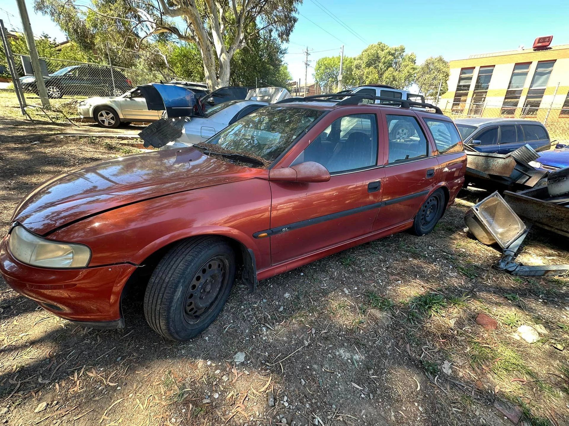 A Red Car Is Parked In A Lot With Other Cars — R N R Wrecking N Scrap Car Removal In Beard, ACT