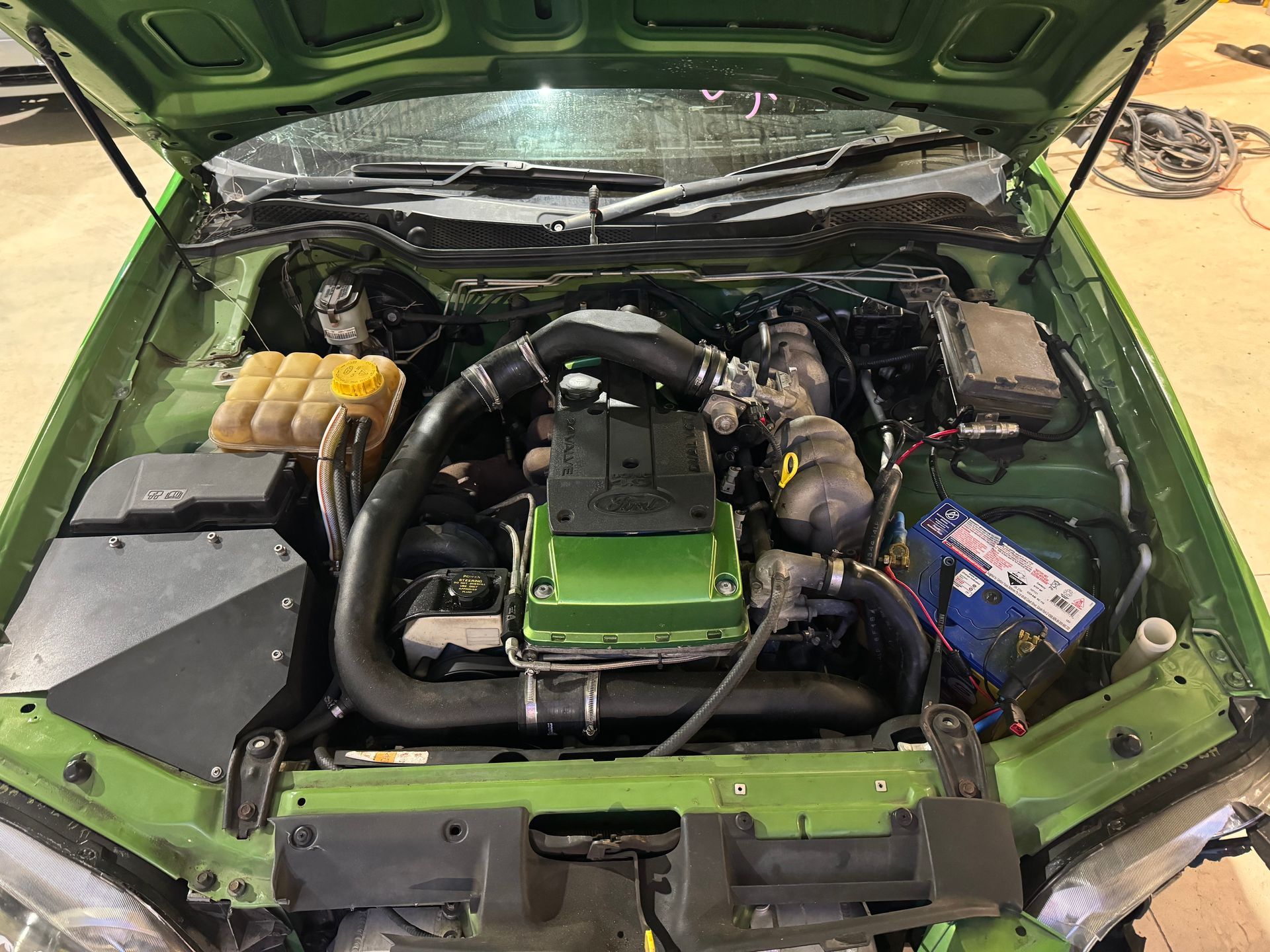 The Engine of a Green Car is Shown With the Hood Open — R N R Wrecking N Scrap Car Removal In Beard, ACT