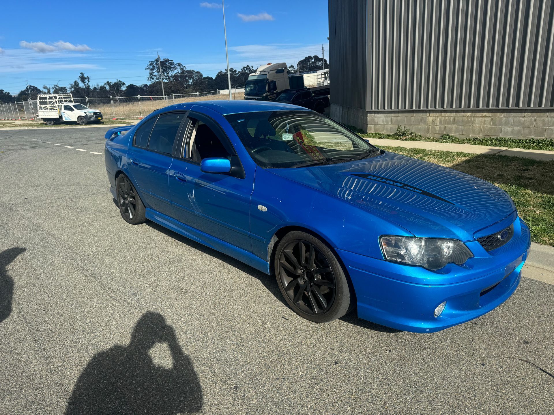A Blue Car is Parked in a Parking Lot Next to a Building — R N R Wrecking N Scrap Car Removal In Beard, ACT
