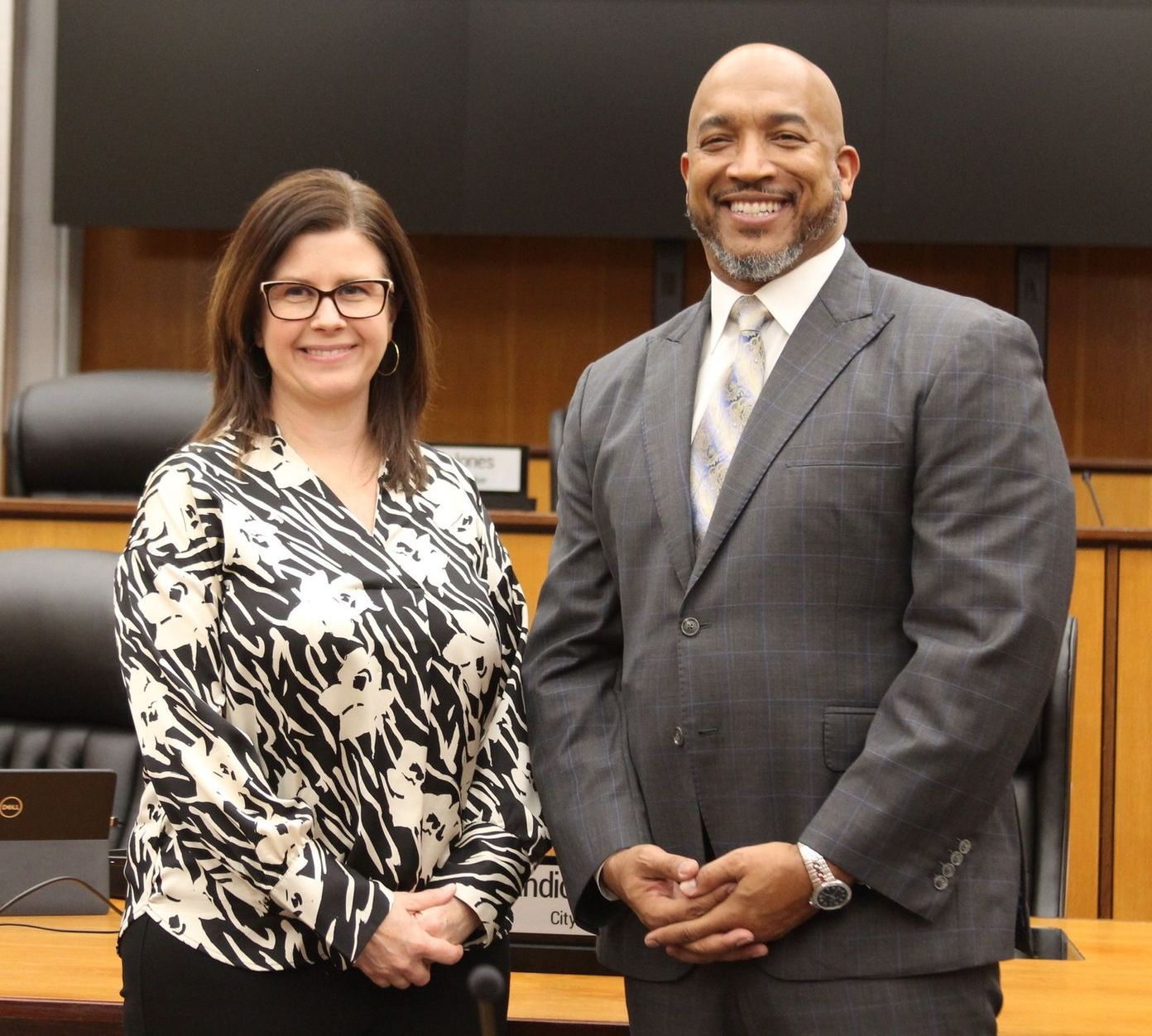 A man in a suit and tie stands next to a woman in a zebra print shirt