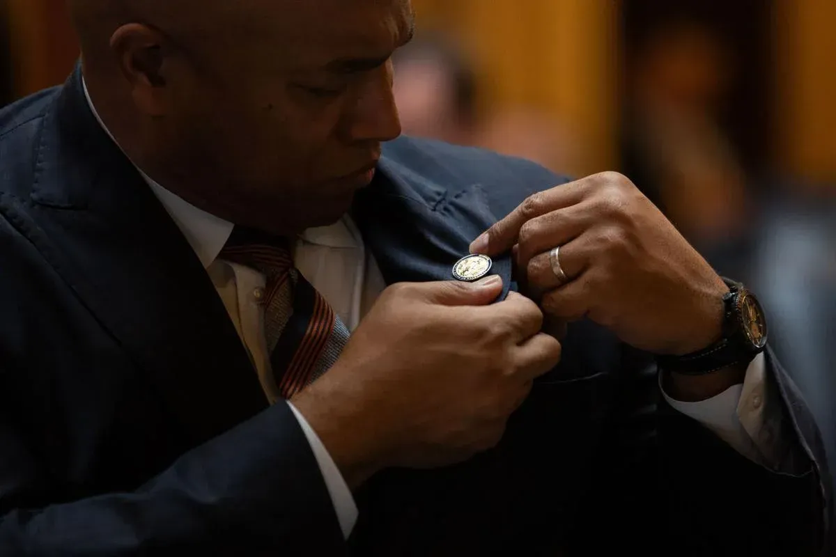 A man in a suit and tie is putting a coin in his pocket.