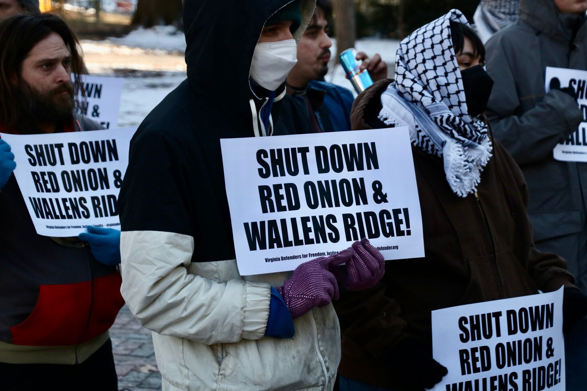 A group of people holding signs that say shut down red onion and wallens ridge
