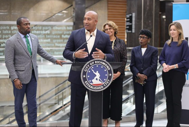 A group of people standing around a podium that says city of roanoke