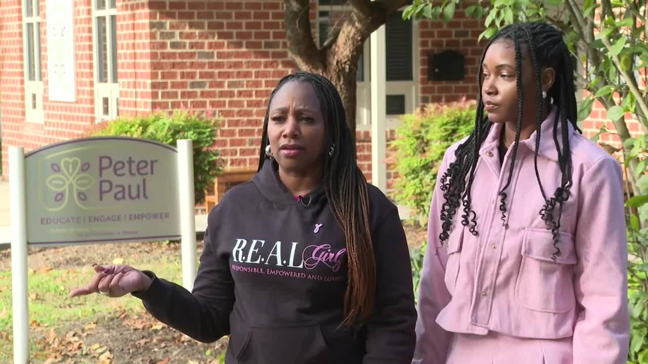 Two women are standing in front of a sign that says peter and paul.