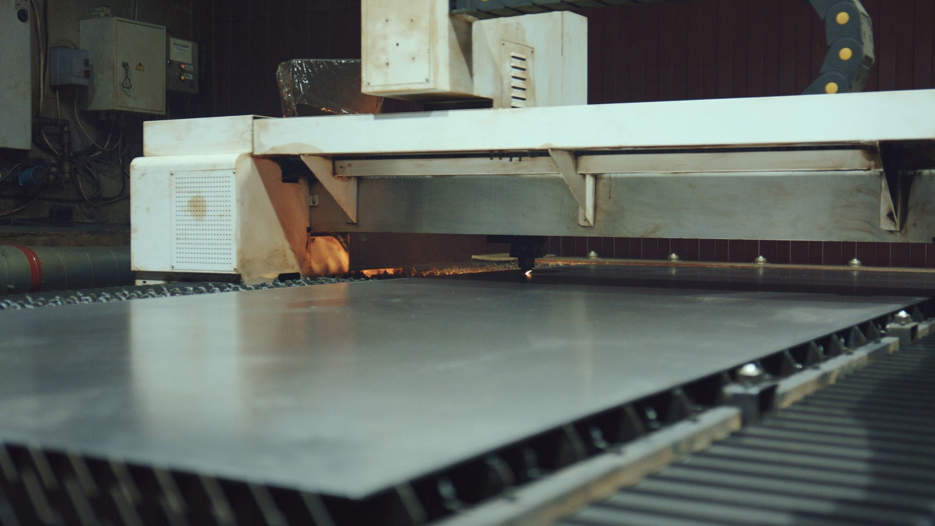Metal sheet being cut by a laser cutter machine in a factory. Metal sheet being cut by a laser cutter machine in a factory.