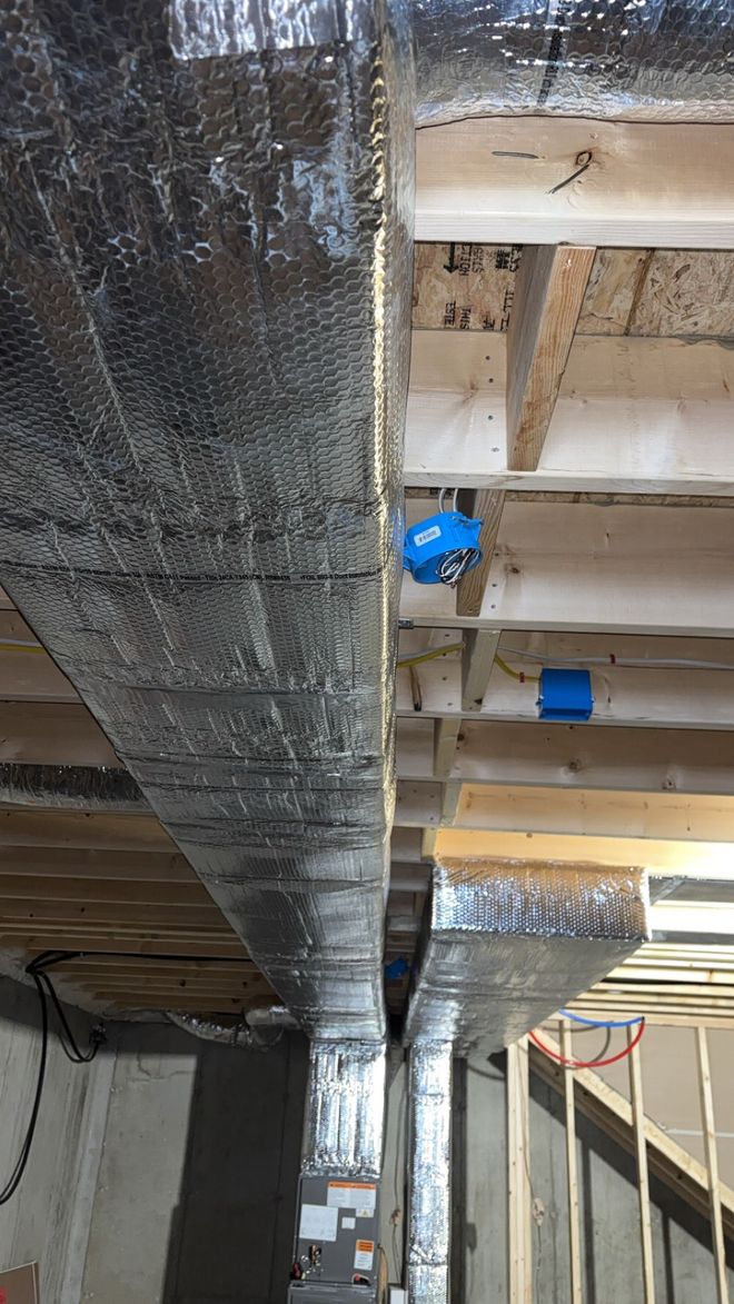 Metallic air ducts installed on a ceiling, bending and curving.