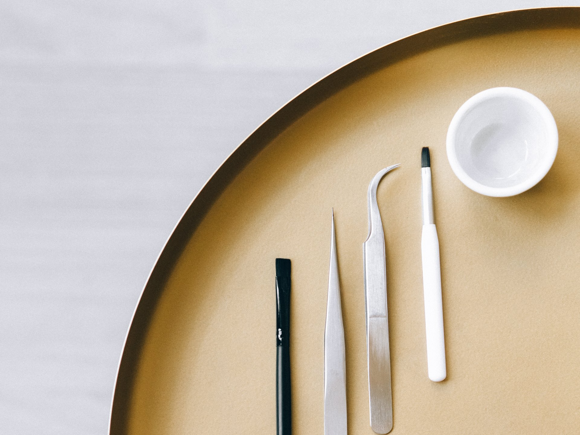 A tray with tweezers and a cup on it