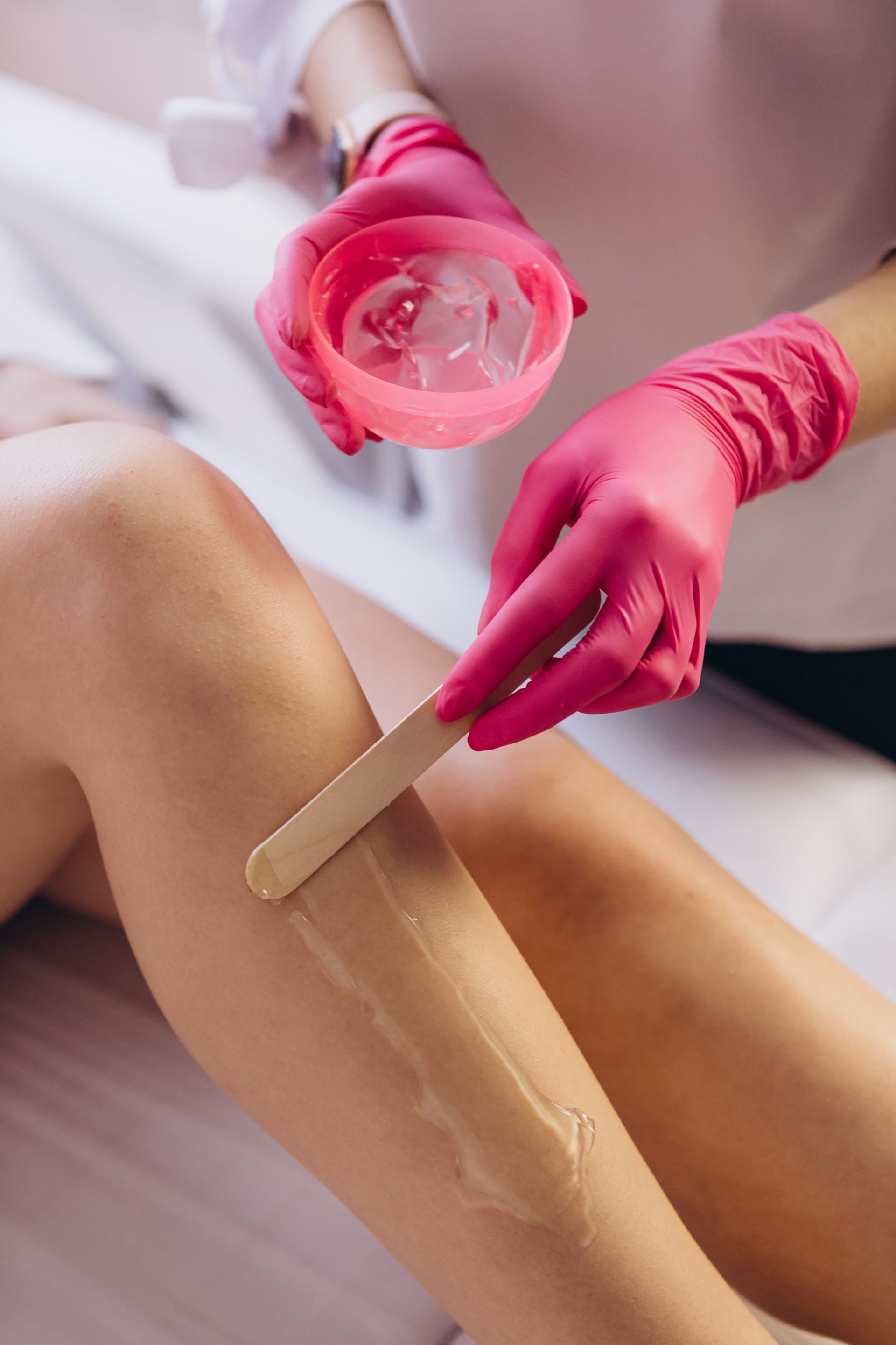 A woman is getting her legs waxed in a beauty salon.