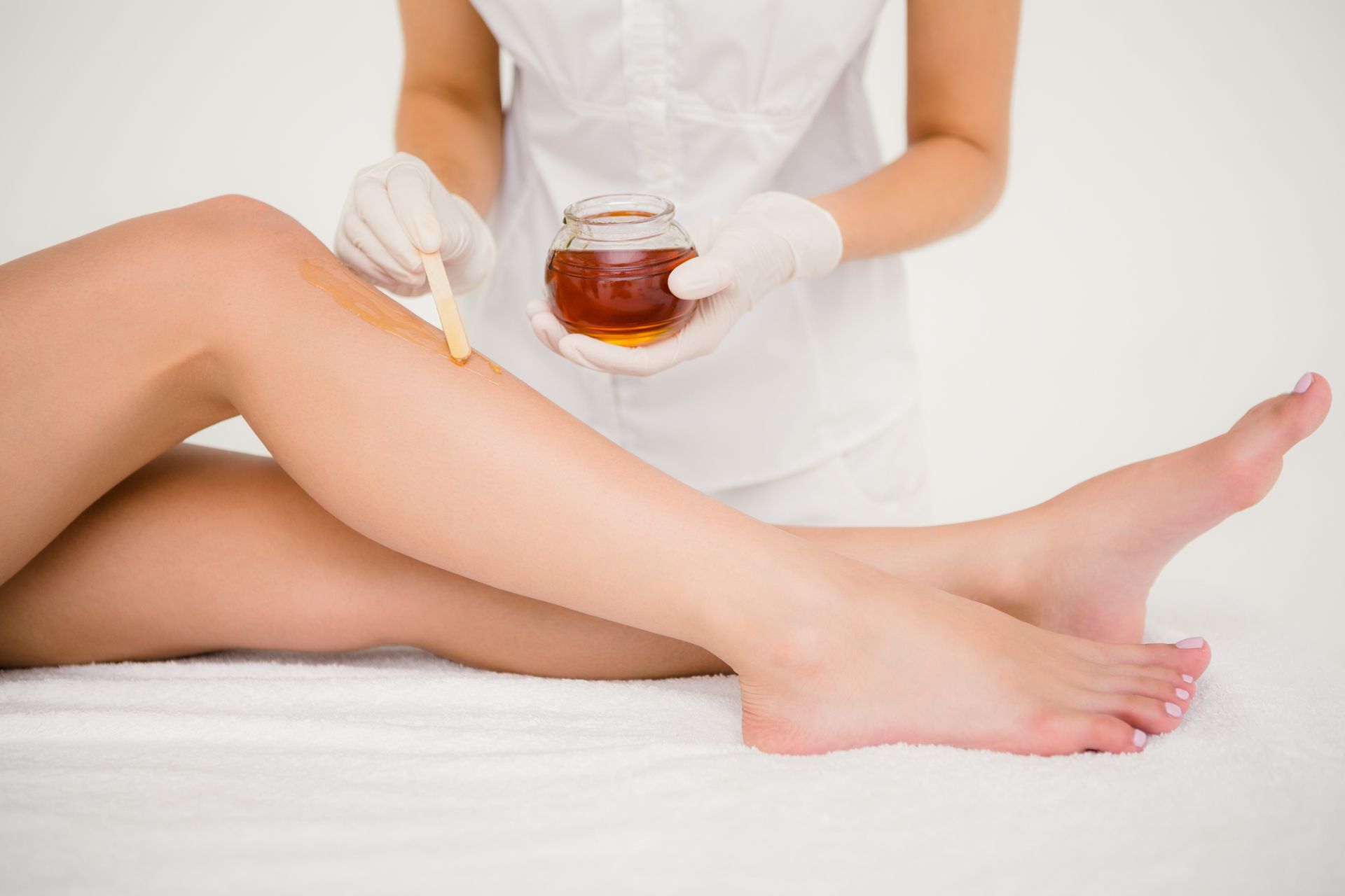 A woman is getting her legs waxed in a beauty salon.