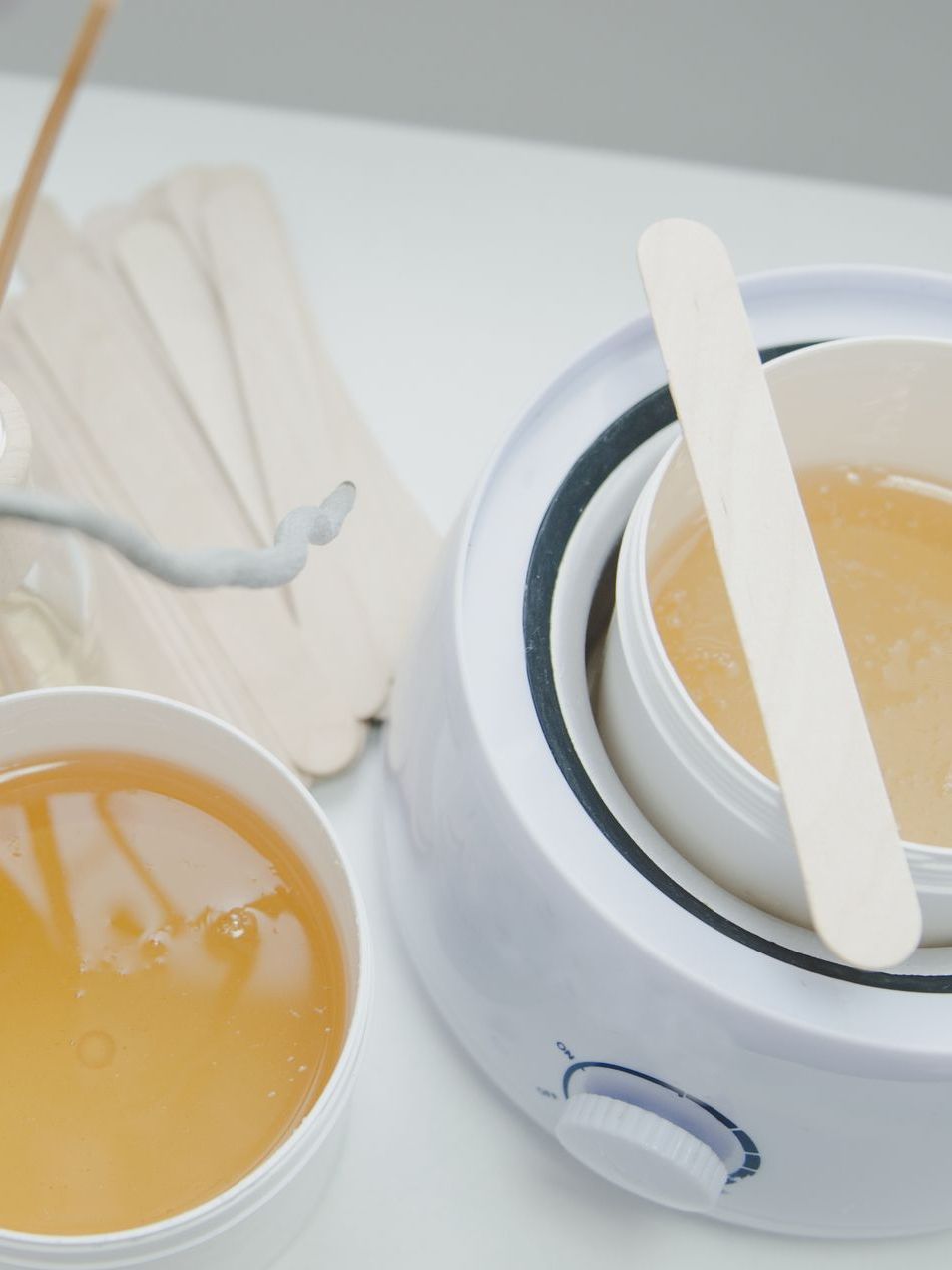 A wax warmer with two bowls of wax next to it