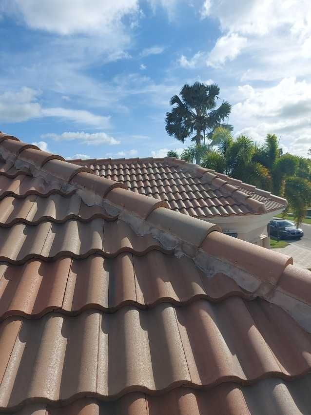 A close up of a tiled roof with a blue sky in the background.
