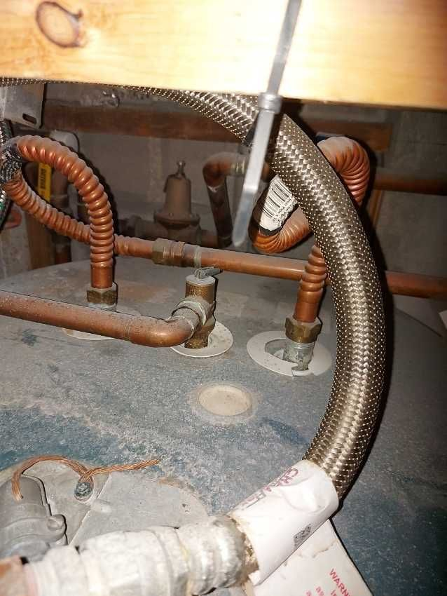 A close up of a water heater with copper pipes