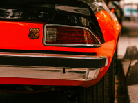 A red car is parked on the side of the road.