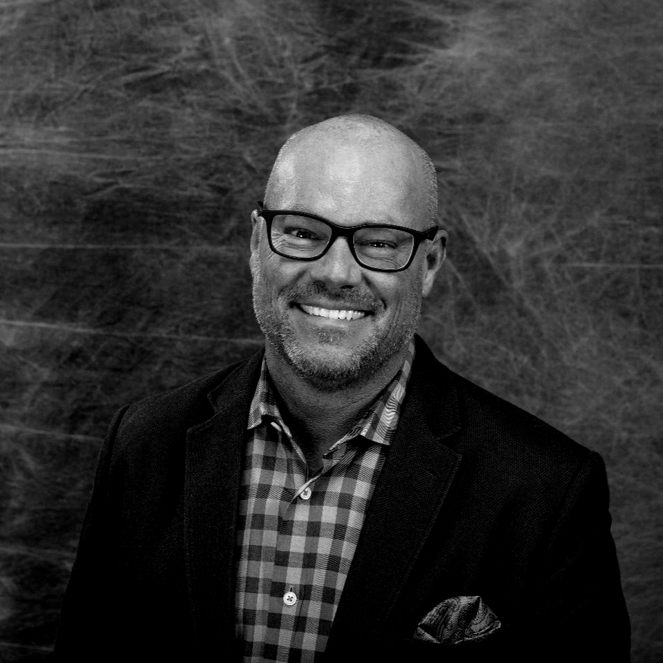 Woman with long hair looking at the camera in a black and white close-up.