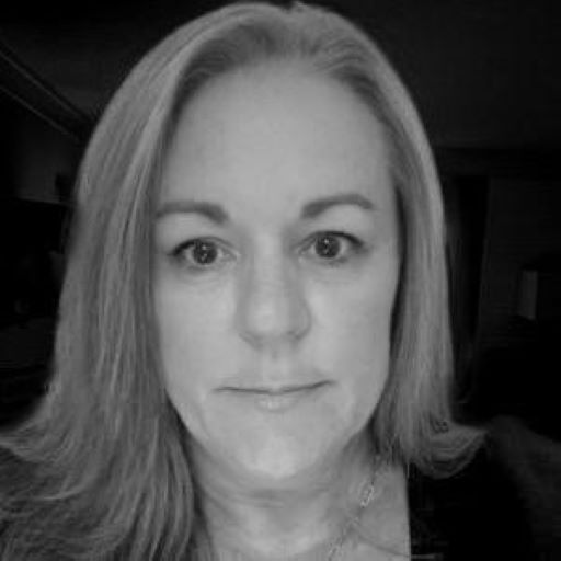 Woman with long hair looking at the camera in a black and white close-up.