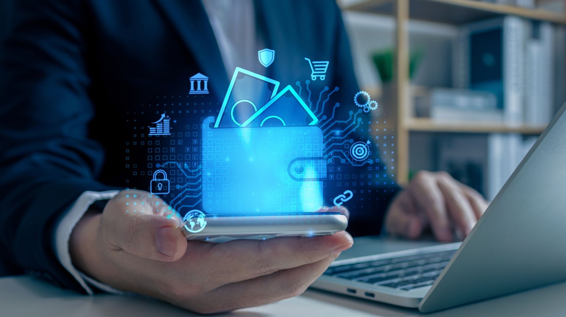Person holding a phone displaying a glowing digital wallet with money and transaction icons. Laptop is in the background.