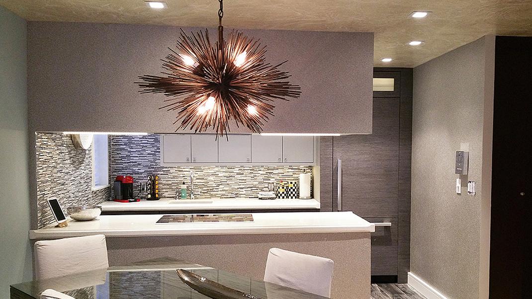A kitchen with a table and chairs and a chandelier hanging from the ceiling.