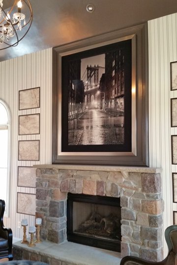 A living room with a fireplace and a picture on the wall above it