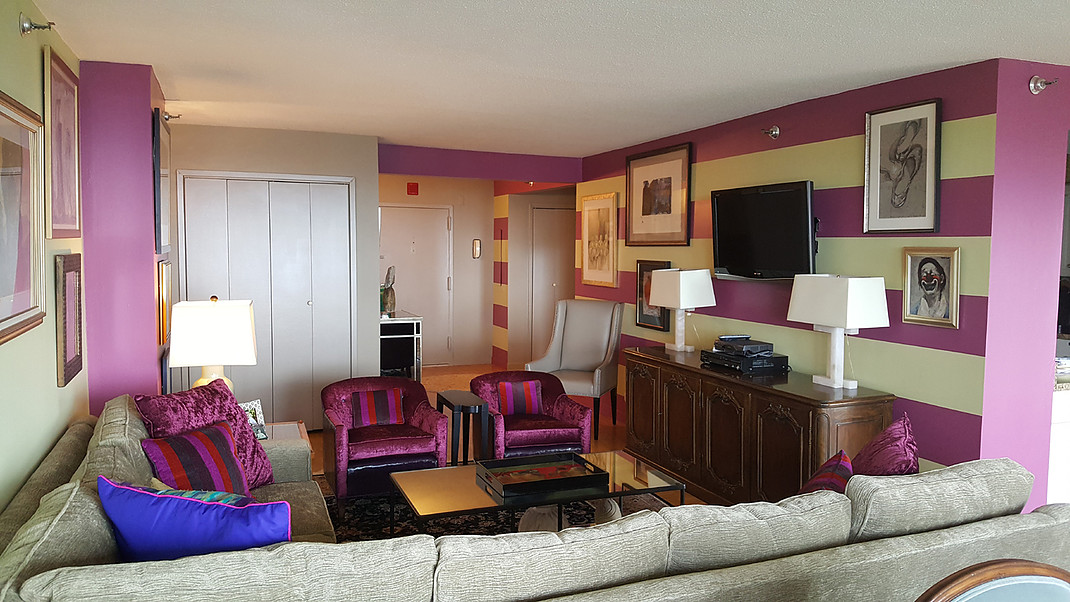 A living room with a couch , chairs , lamps and a television.