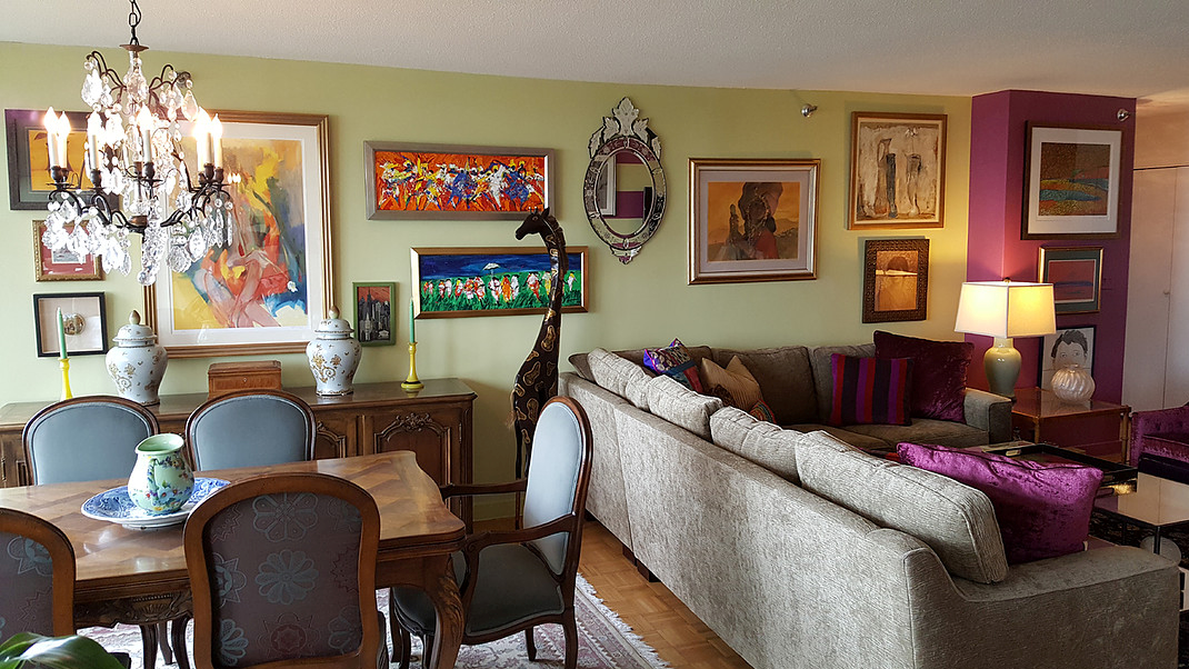 A living room with a couch , table , chairs and a chandelier.