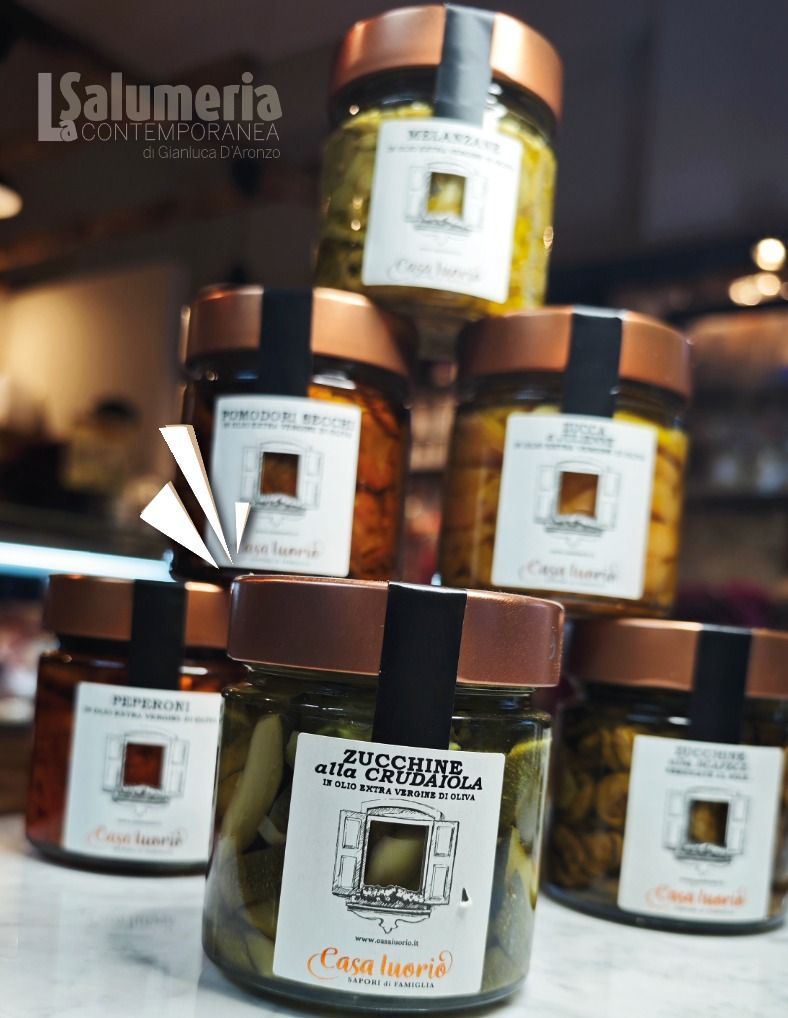 Una piramide di barattoli di vetro contenenti cibo, etichettati