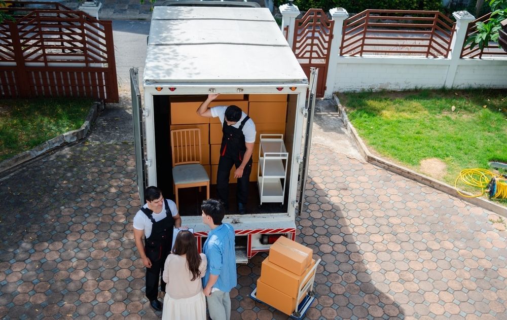 A Group of People Are Standing in Front of a Moving Truck — Johns Removals Newcastle In Wyong, QLD