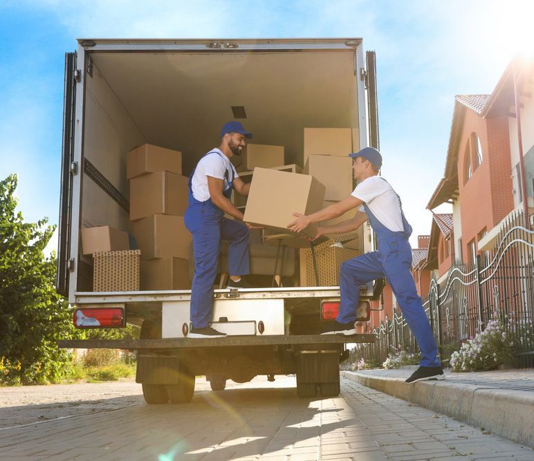 Two Men Are Loading Boxes Into a Moving Truck — Johns Removals Newcastle In Lake Macquarie, NSW