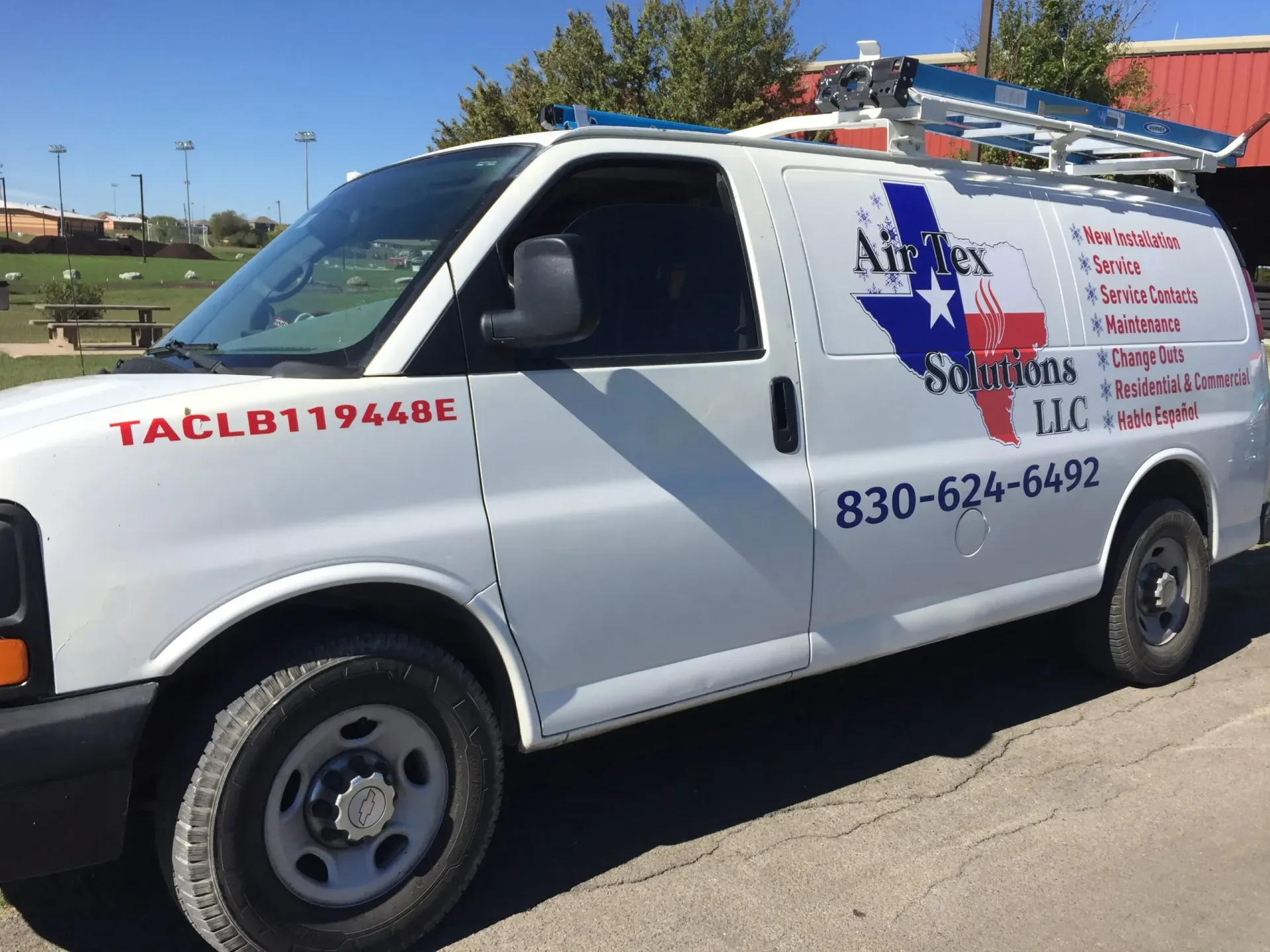 A white van is parked on the side of the road