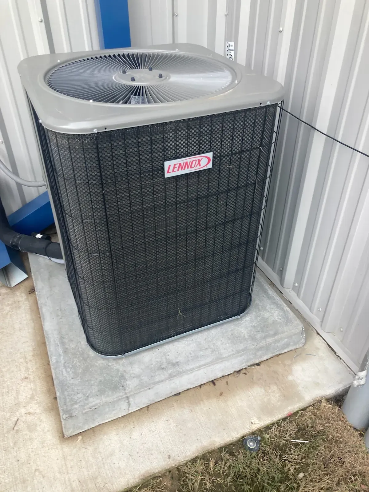 A large air conditioner is sitting on top of a concrete platform.