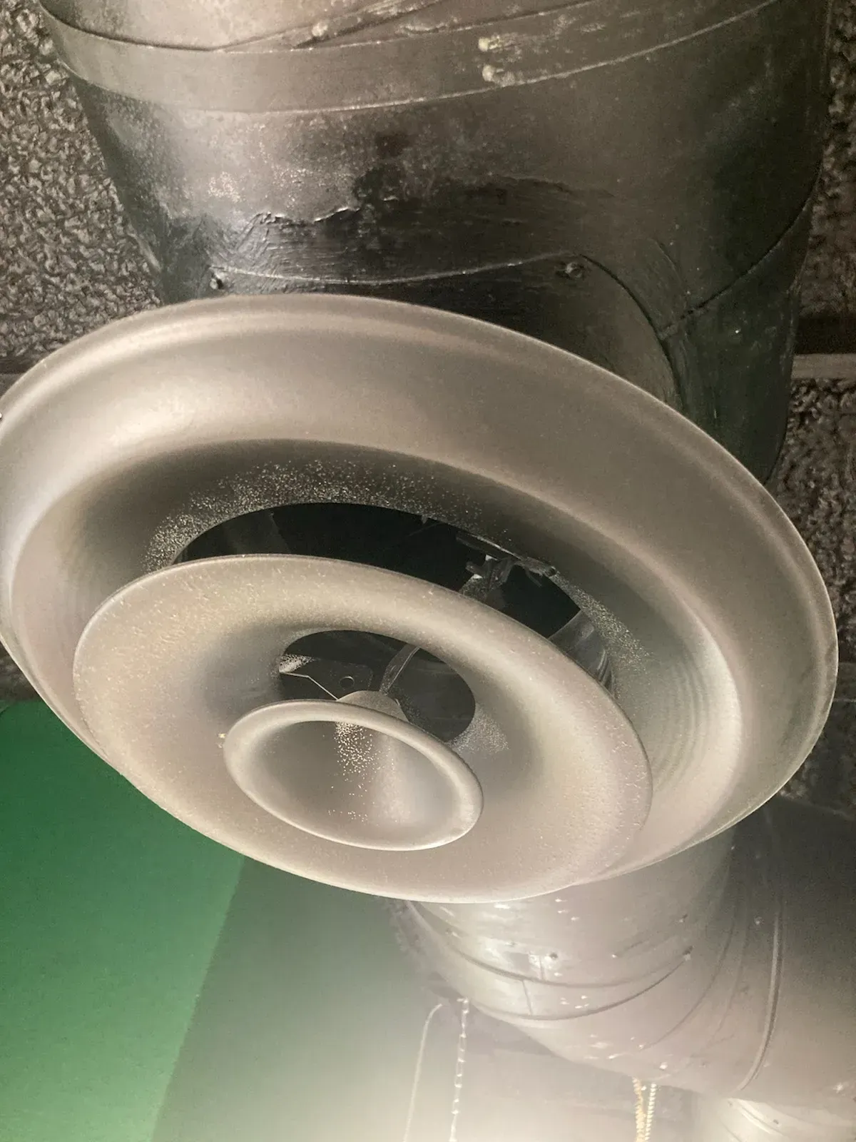 A close up of an air vent on the ceiling of a building.