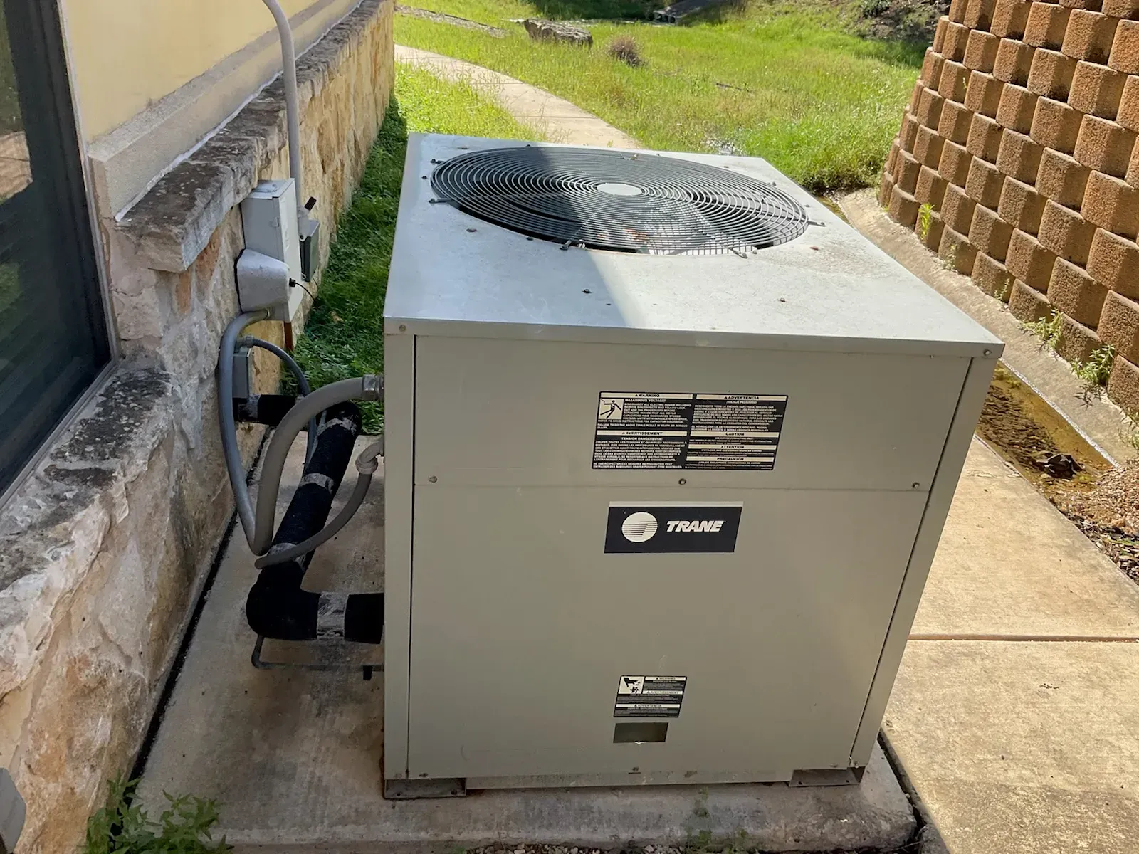 A large air conditioner is sitting on the side of a building.