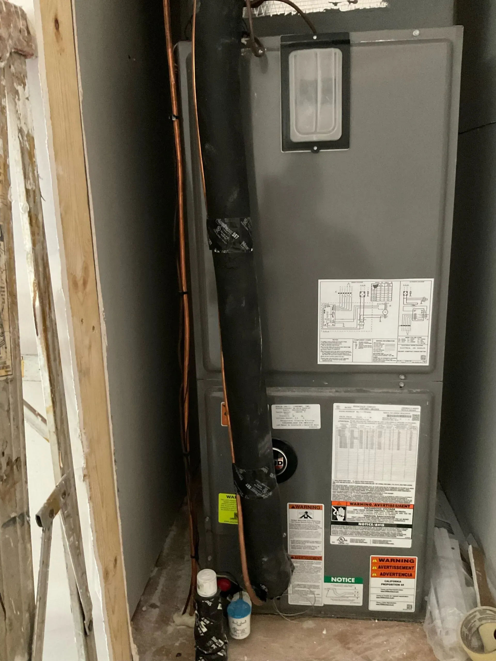 An air conditioner is sitting in a corner of a room.