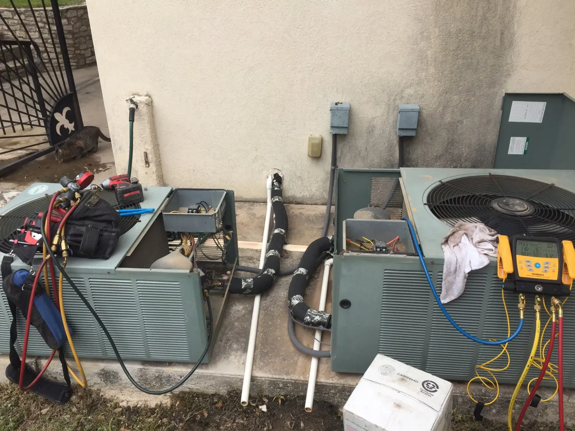 A couple of air conditioners are sitting next to each other on the side of a building.