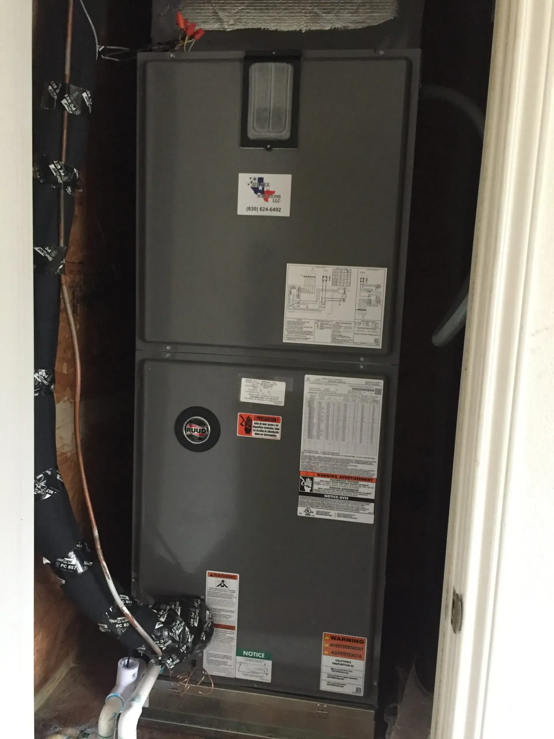 An air conditioner is sitting in a room next to a door.