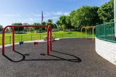Mobile Detailing-a playground with swings and a flag in the background .