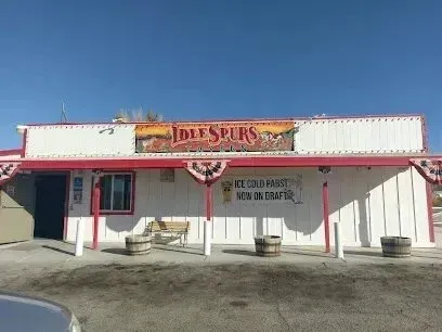 Mobile Detailing-Idlespurs bar with red trim and banner. White exterior, brown barrels, and clear sky.