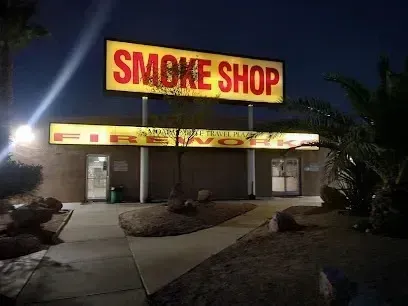 Mobile Detailing-Smoke Shop and Firework store at night, lit signs in yellow and red.