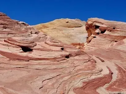 Mobile Detailing-Red and tan layered rock formations under a clear blue sky.