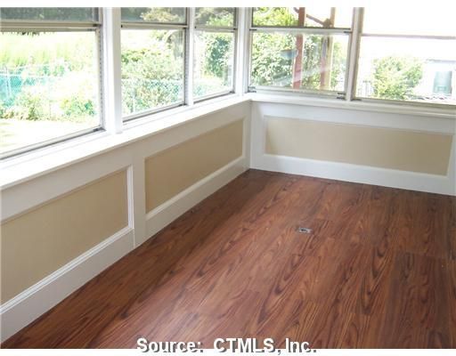 An empty room with hardwood floors and a window
