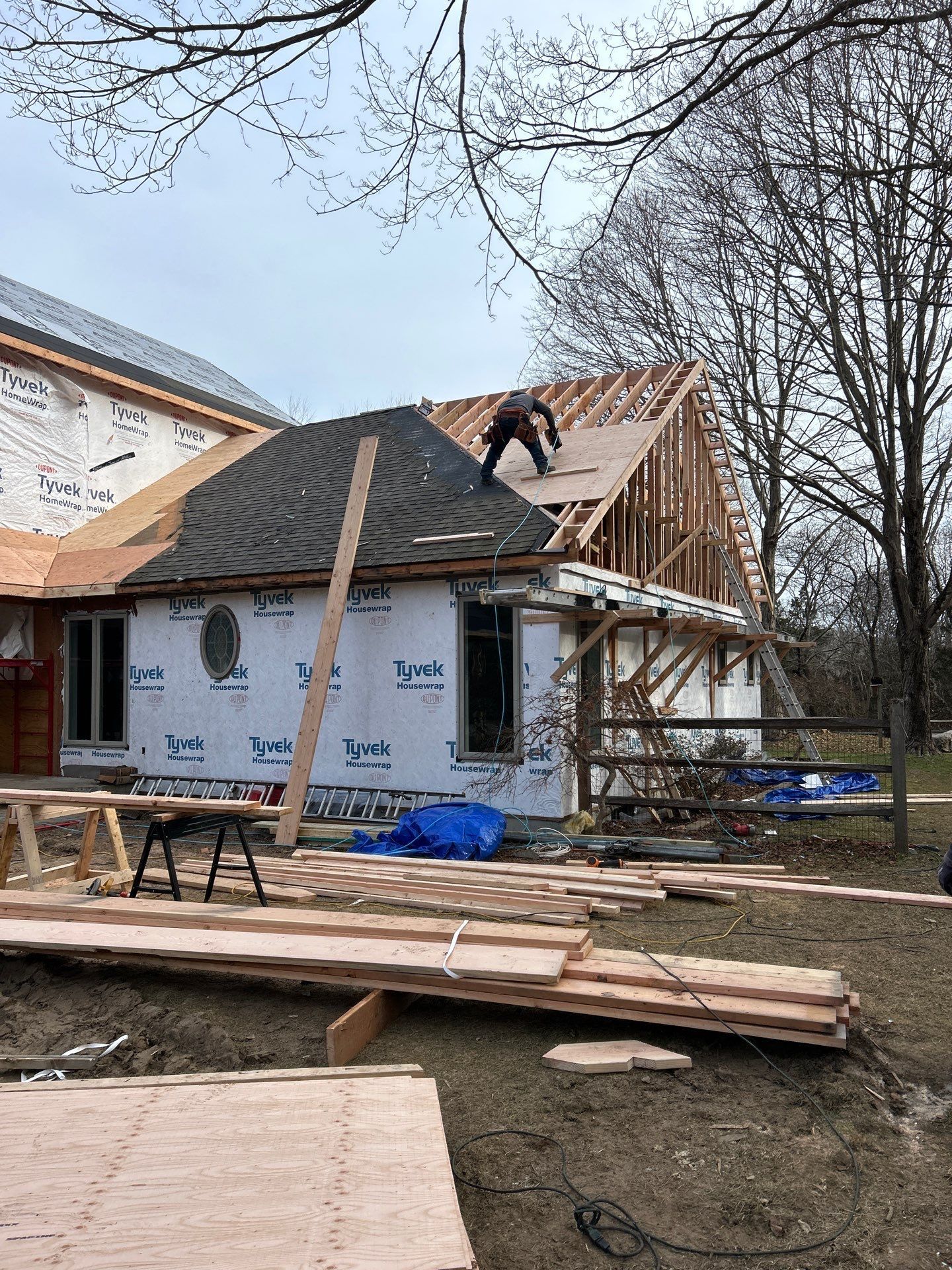 A man is working on the roof of a house under construction.
