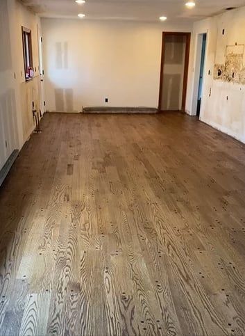 A large room with hardwood floors and white walls.