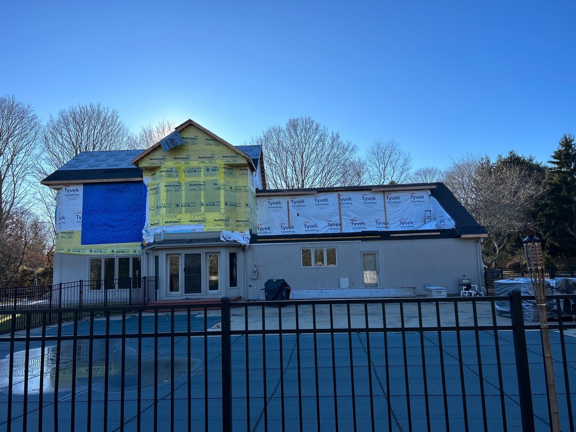 A house under construction with a fence in front of it