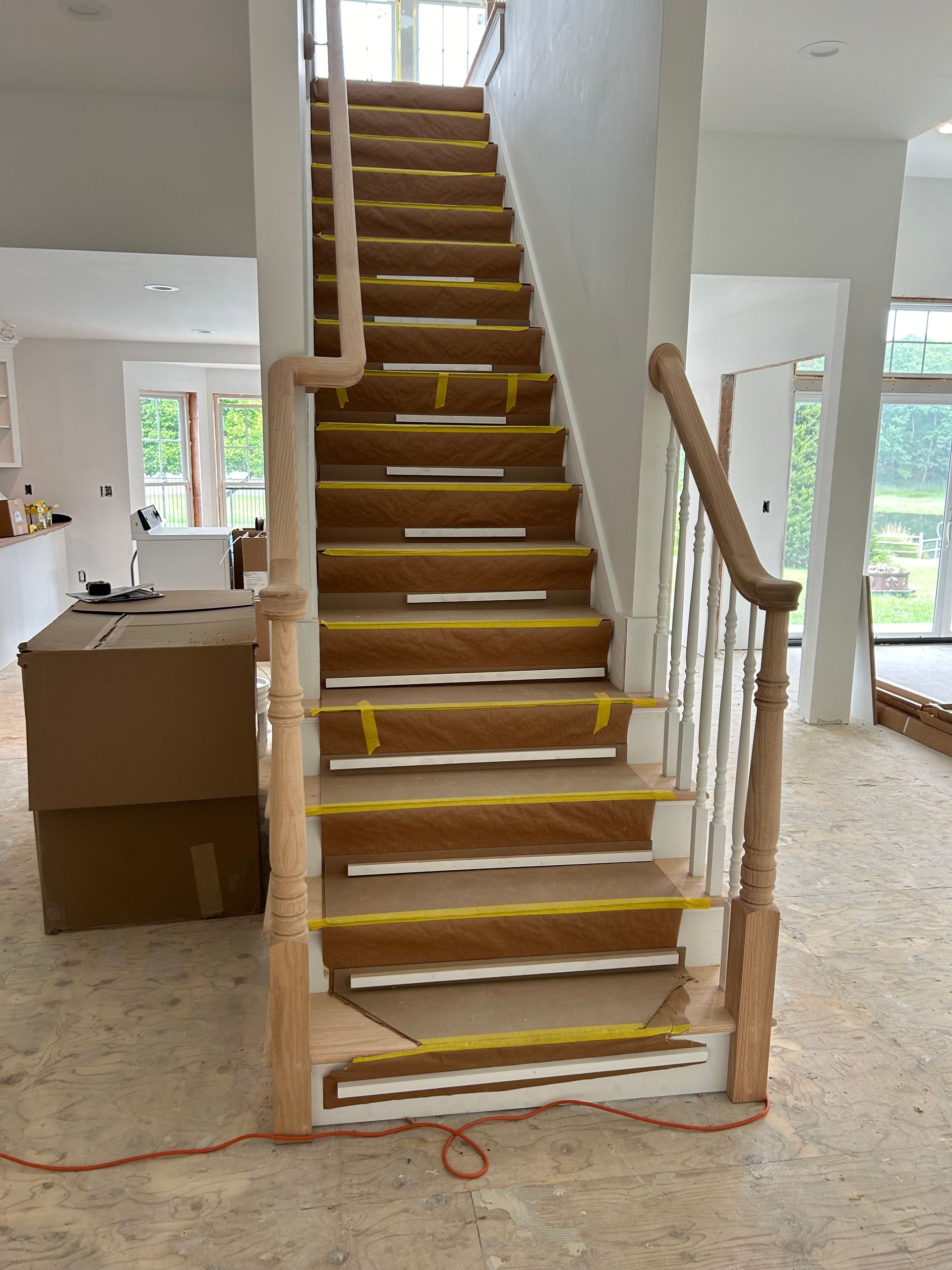 A wooden staircase is being built in a house.