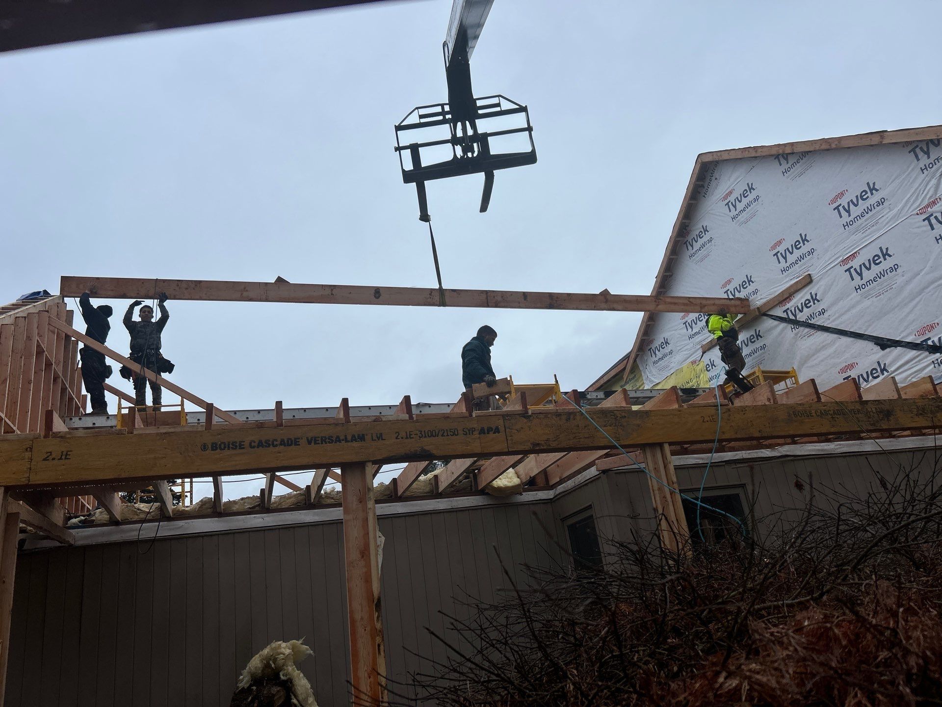 A group of construction workers are working on the roof of a building.