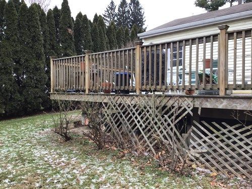A house with a large wooden deck in front of it