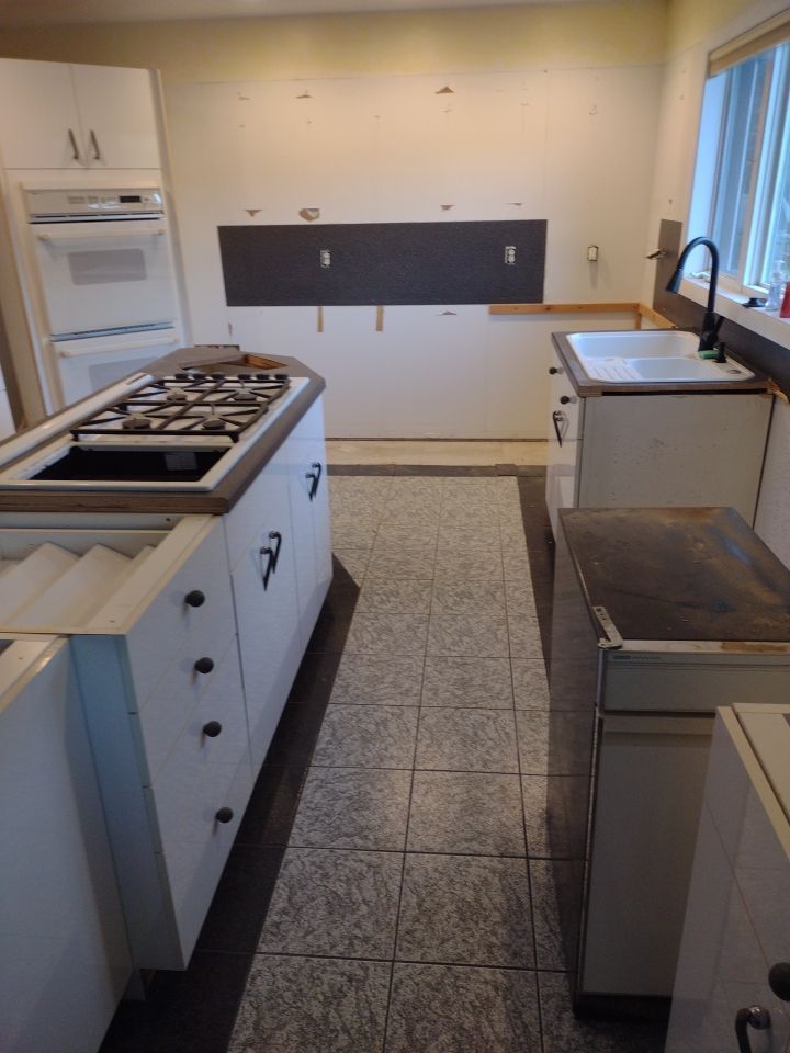 A kitchen with a stove top oven and a sink