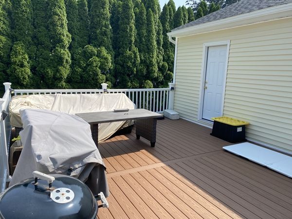 A deck with a grill and a couch on it