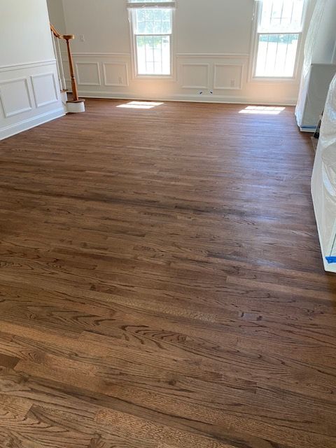 A living room with hardwood floors and white walls.