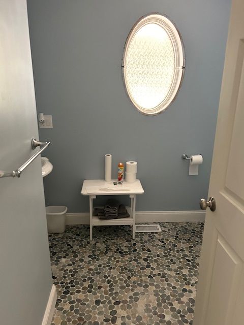 A bathroom with blue walls and a round mirror