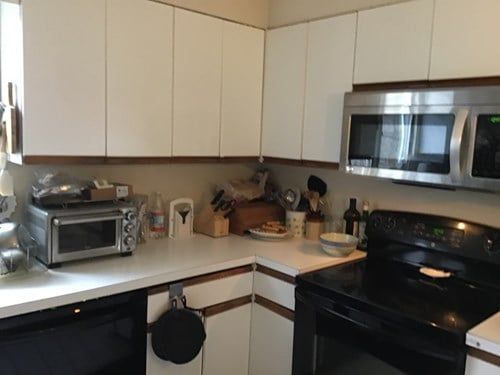 A kitchen with stainless steel appliances and white cabinets